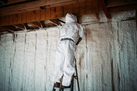 worker applying spray foam insulation on wall - Keller, TX
